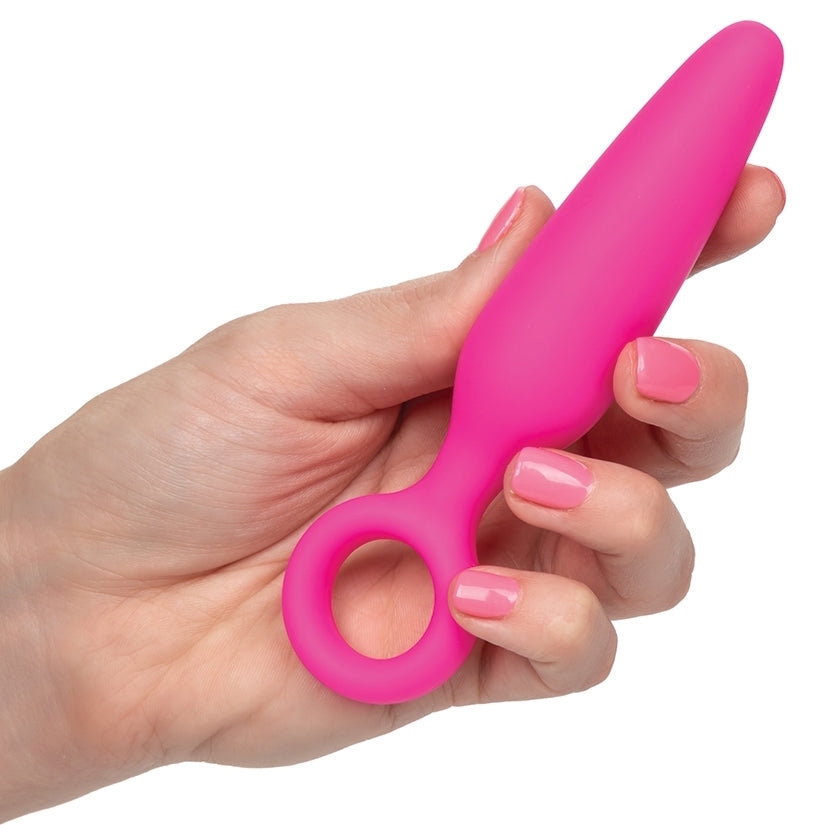 Hand holding a pink tool against a white background