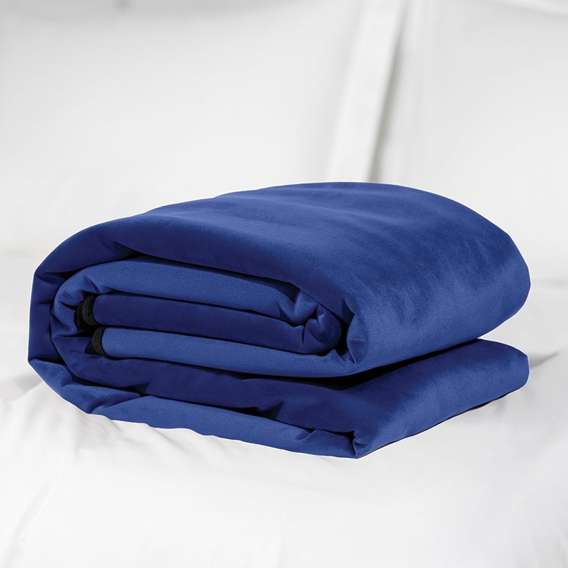 Folded blue comforter on a white bed
