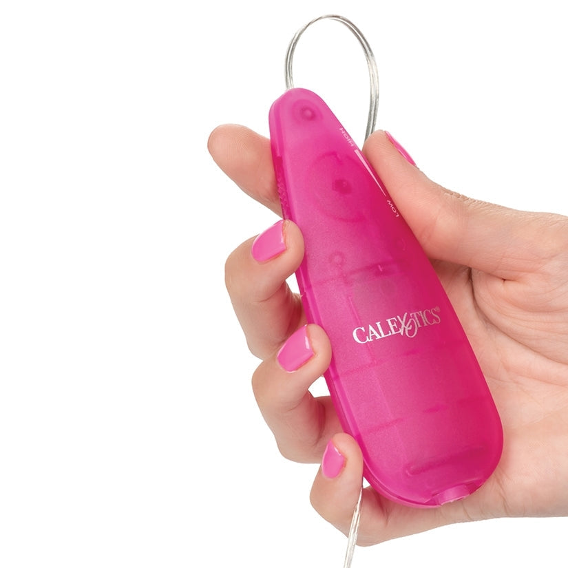 Pink electronic device held in a hand with a white background