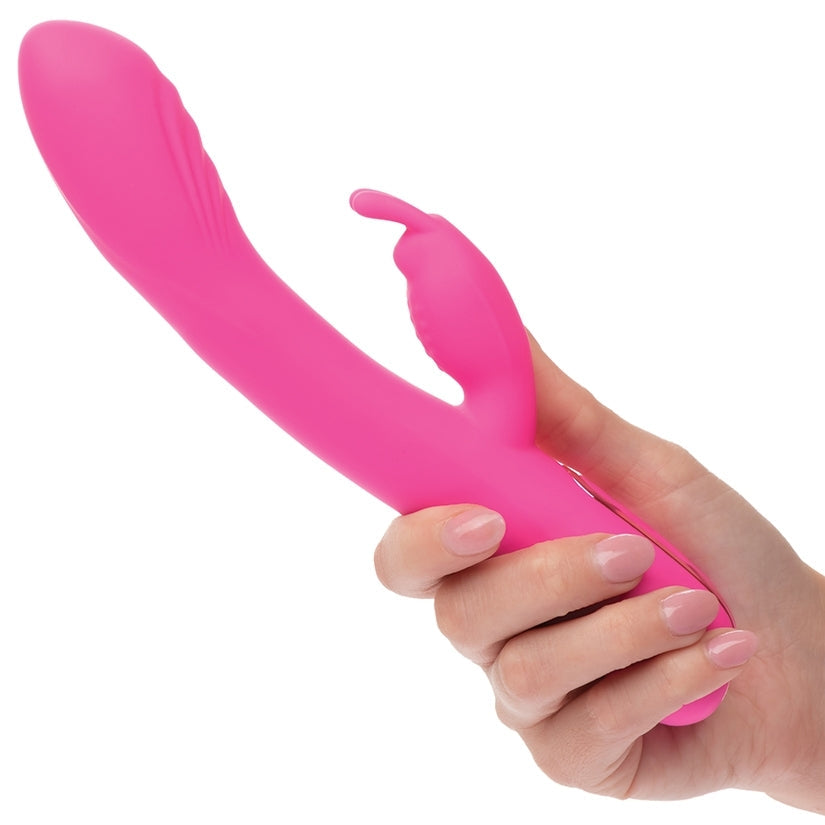 Pink silicone tool held by a hand on a white background