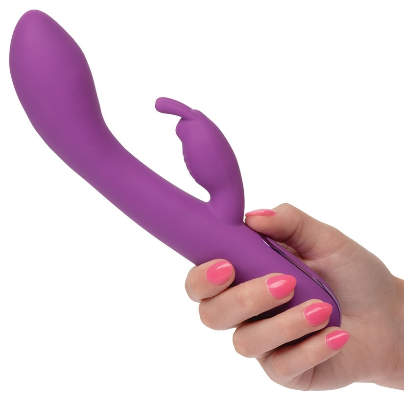 Purple toy held by a hand with pink nail polish on a white background
