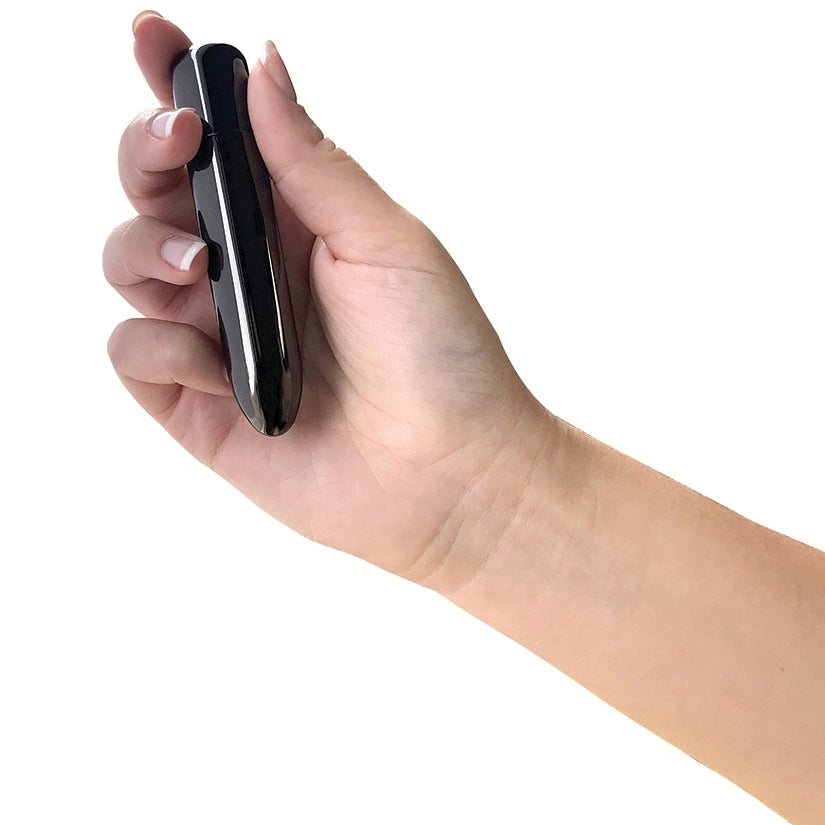Hand holding a black electronic device on a white background