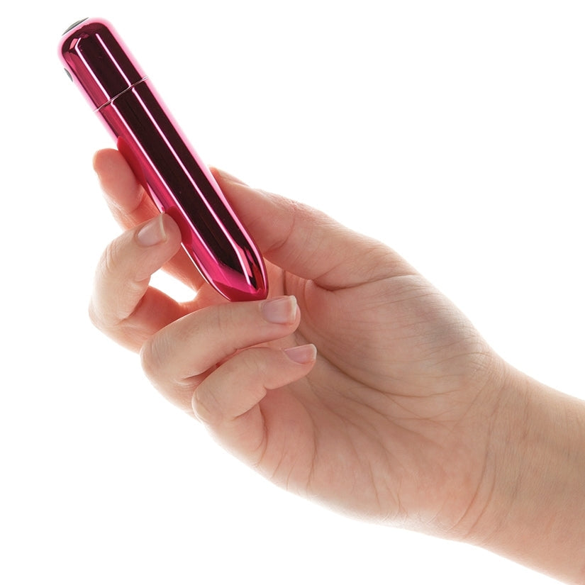 Hand holding a pink cylindrical object against a white background