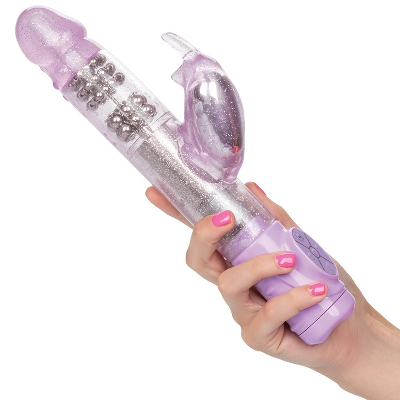 Purple and clear toy held by a hand with pink nail polish on a white background