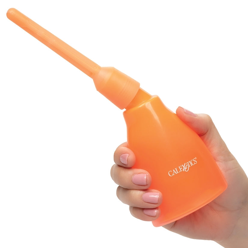 Orange plastic tool held in a hand with a white background